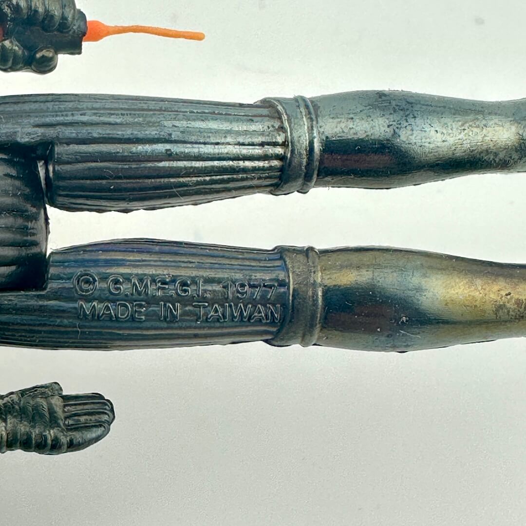 Close-up of a metallic object with 'Made in Taiwan' engraving on a white background