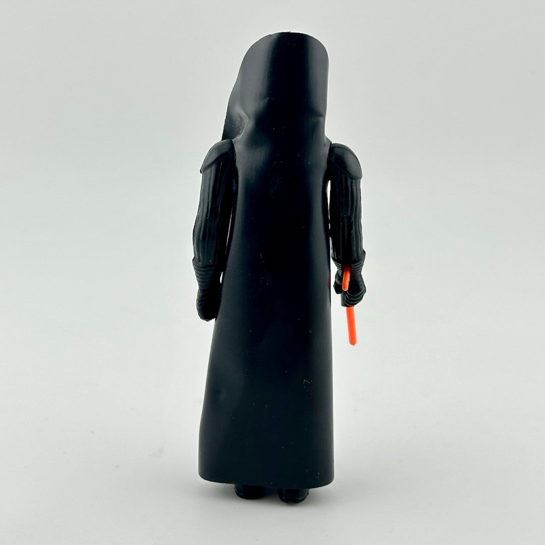 Action figure in all black, black helmet, & black cape, with red lightsaber emerging from right hand. Back.
