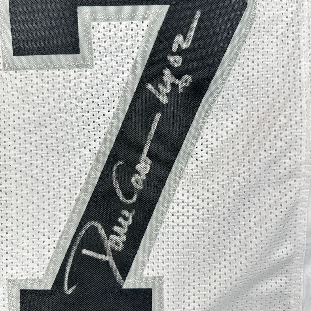 Close-up of a sports jersey with a silver signature on number patch on a white jersey background