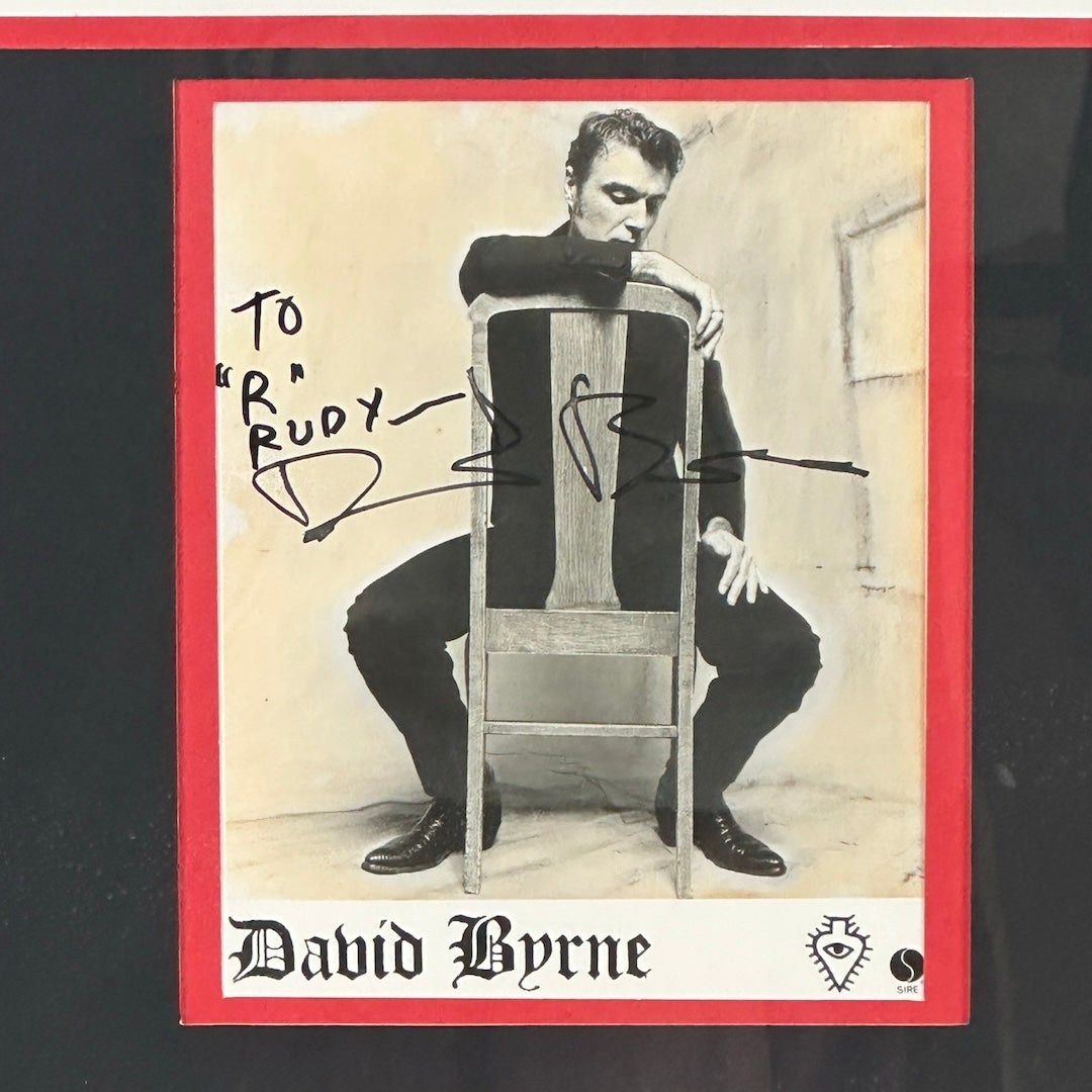 Close up of partial poster with image of seated Byrne and black marker inscription next to him. Printed name below.