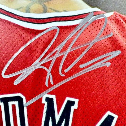 Red sports jersey with a signature on the back.