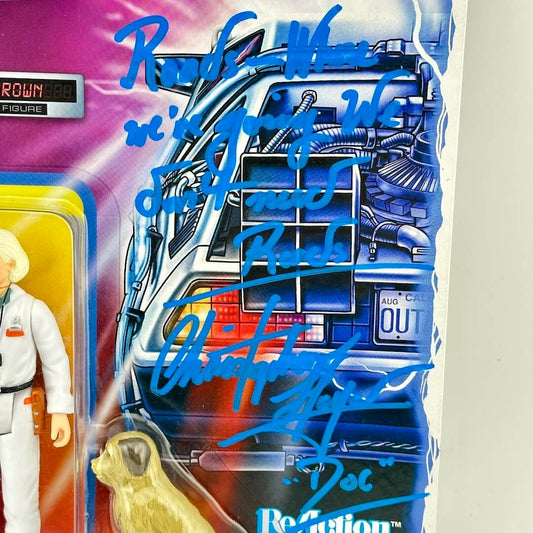 Toy figure in packaging with blue autograph text on a white background