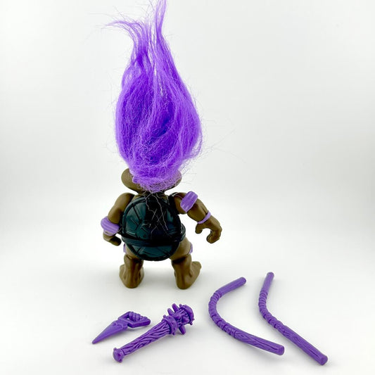 Toy figure with purple hair and accessories on a white background