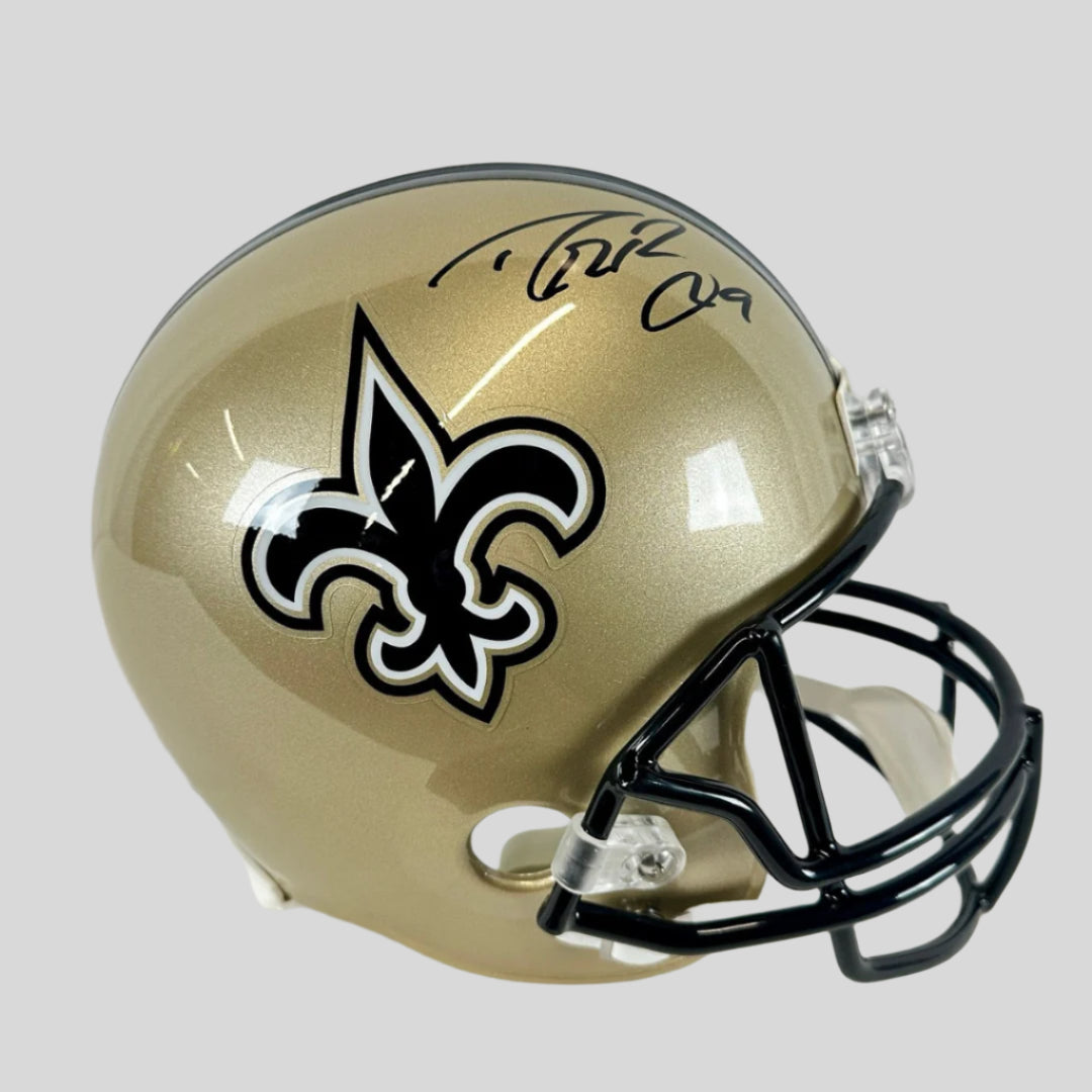 A full-size authentic New Orleans Saints helmet with Drew Brees's signature in black marker on the side.