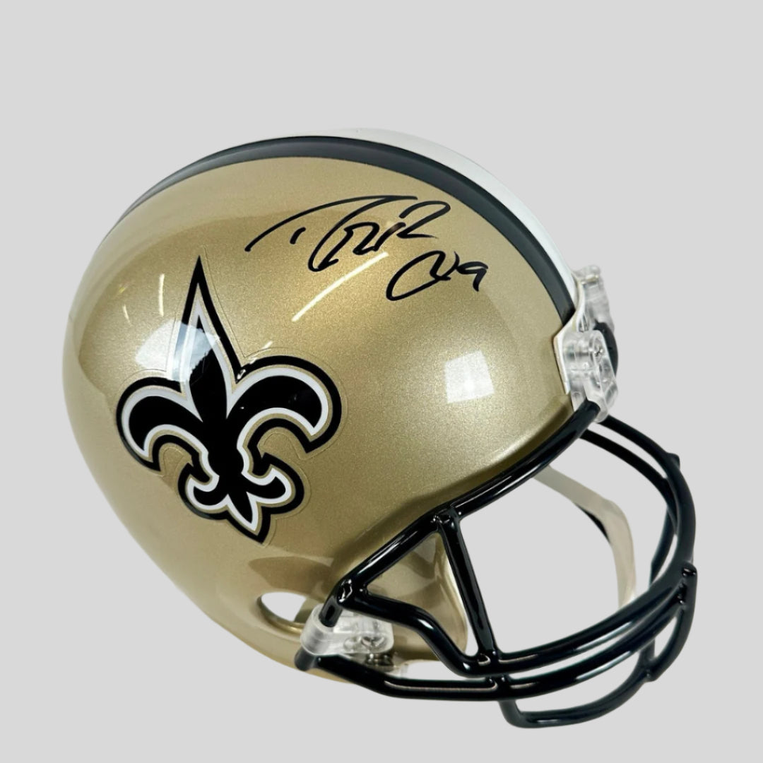 A full-size authentic New Orleans Saints helmet with Drew Brees's signature in black marker on the side.