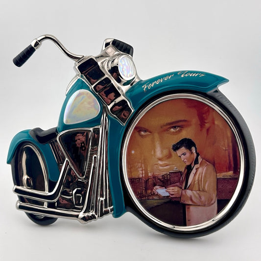 Motorcycle shaped ceramic plate with Elvis portrait in front wheel of him in the sunset & dressed in gold in foreground.