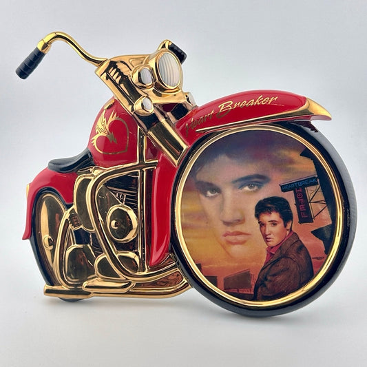 Motorcycle shaped ceramic plate with Elvis portrait in front wheel of him in the sunset & dressed in brown in foreground.