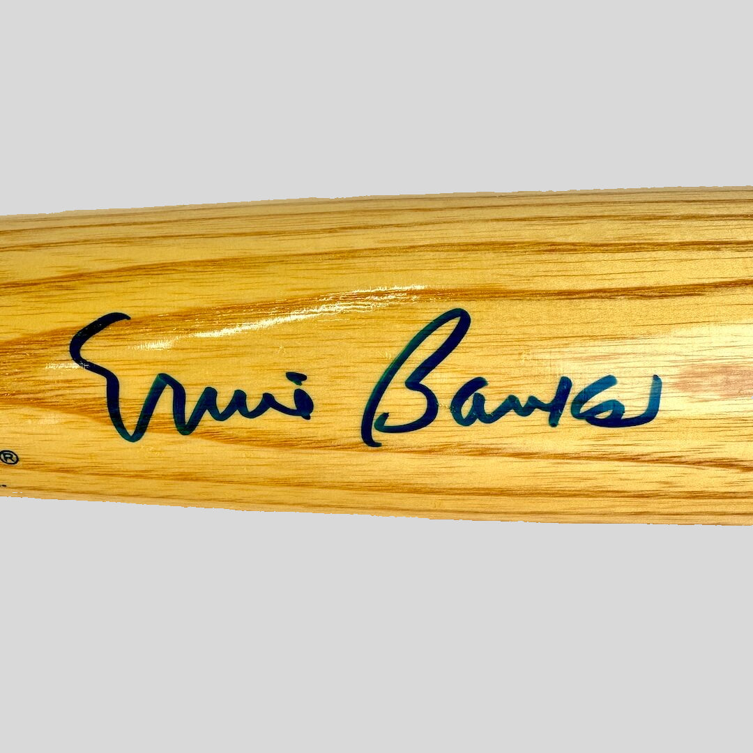 Wooden baseball bat with a signature on a white background