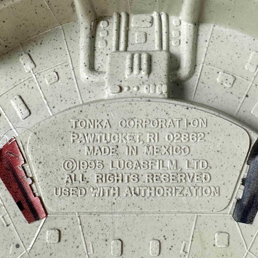 Close-up of a textured light gray plastic molded piece with embossed text of COO and copyright information.