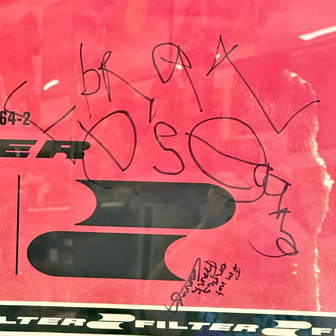 Close-up of a red and black poster packaging with 'FILTER' text and black signature.