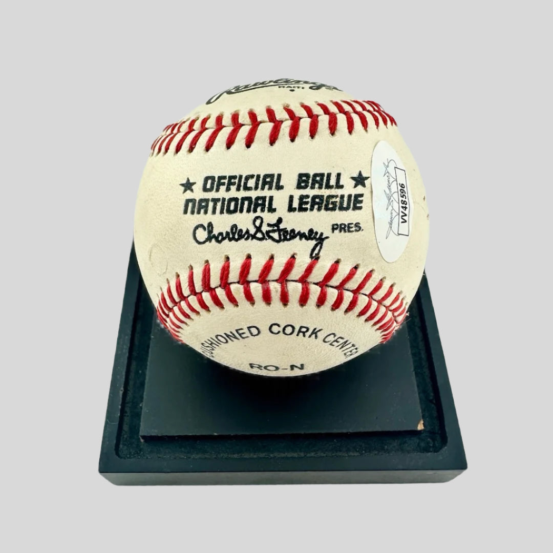 Signed Rawlings baseball with JSA sticker & official ball stamp, resting on black base.