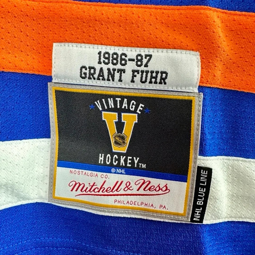 Close up of sewn on hem patch with Vintage Hockey & player info: "Grant Fuhr 1986-87" NHL Blue Line