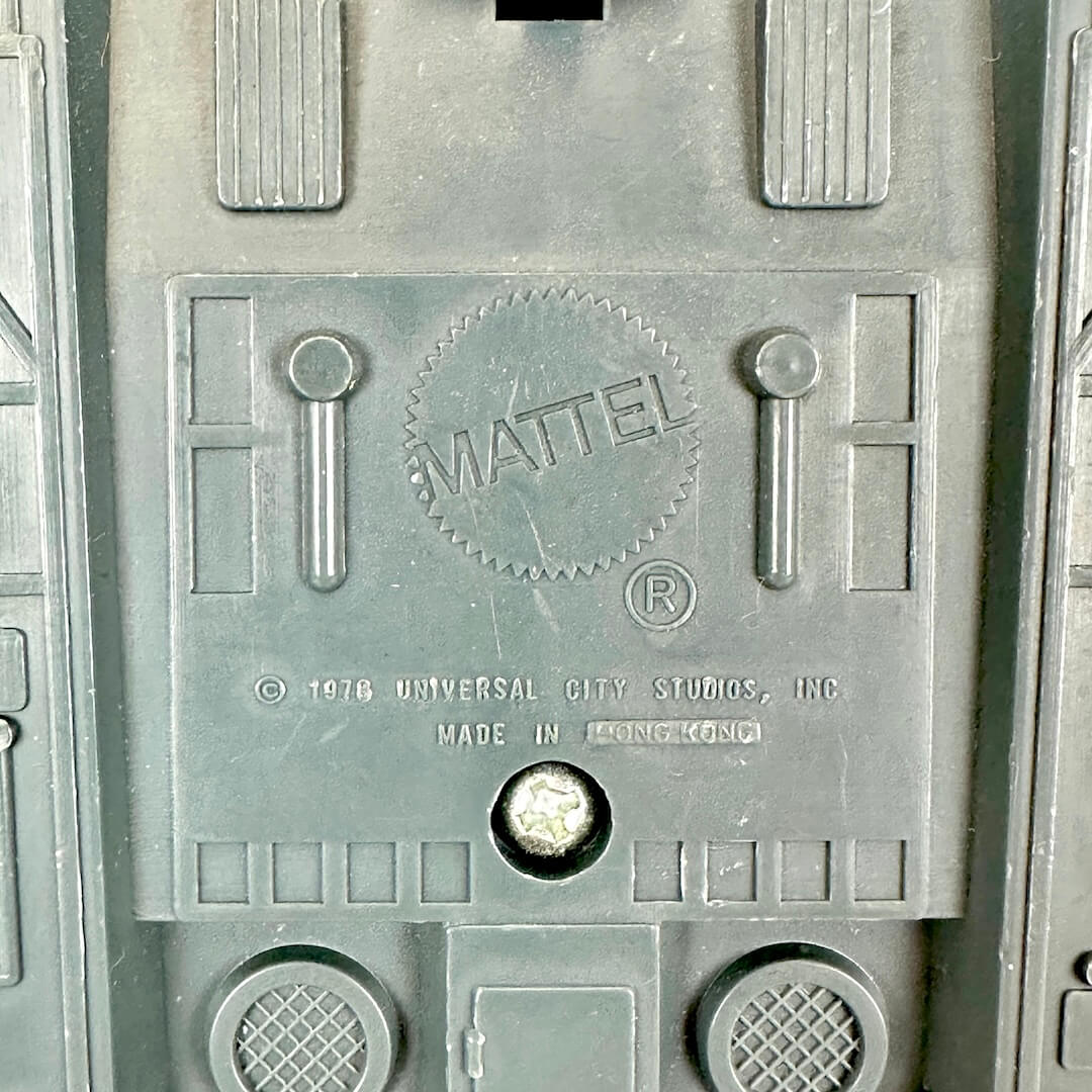 Close-up of a gray molded plastic surface with embossed MATTEL logo and copyright text.