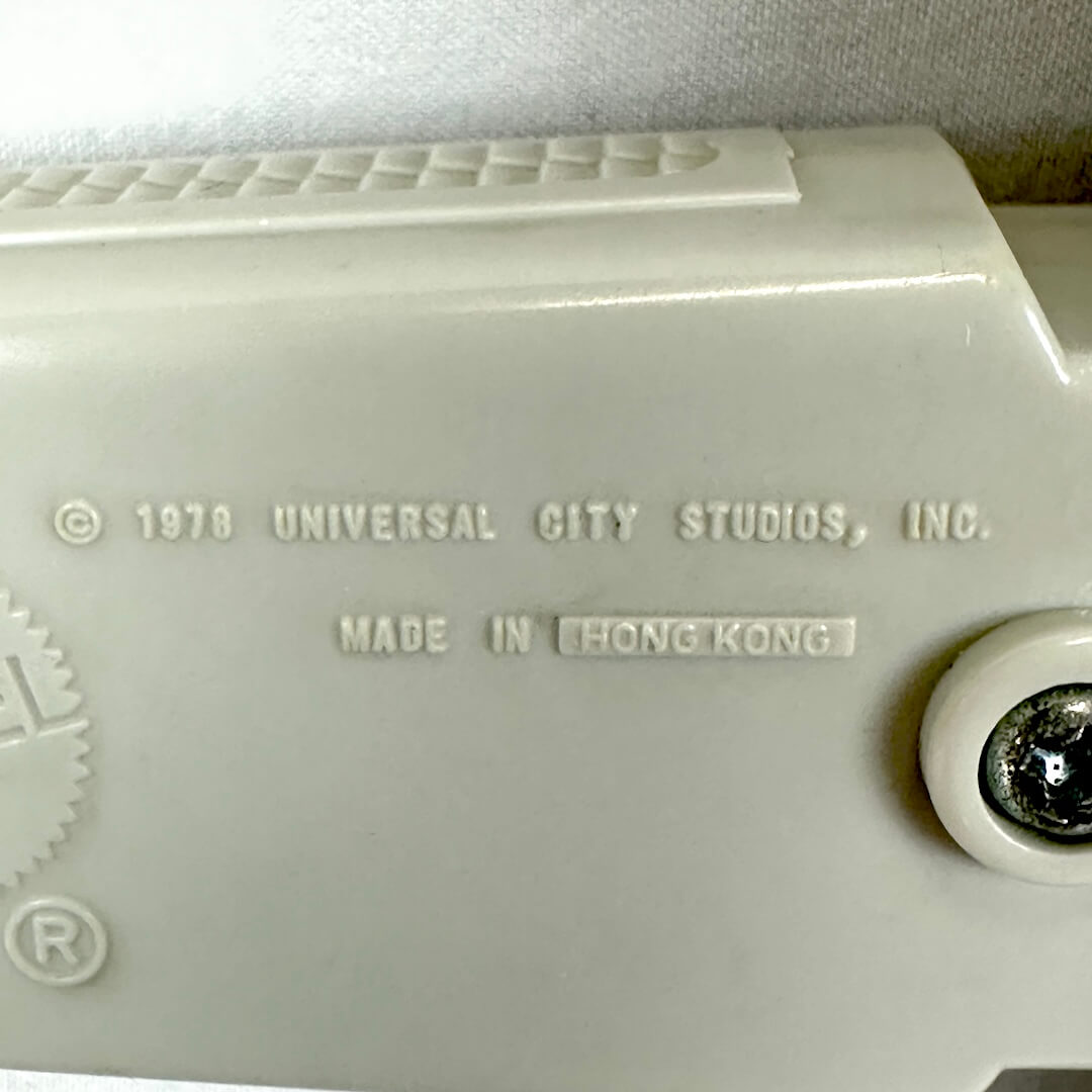 Close-up of a vintage off-white plastic toy with embossed text reading '© 1978 UNIVERSAL CITY STUDIOS, INC. MADE IN HONG KONG'.