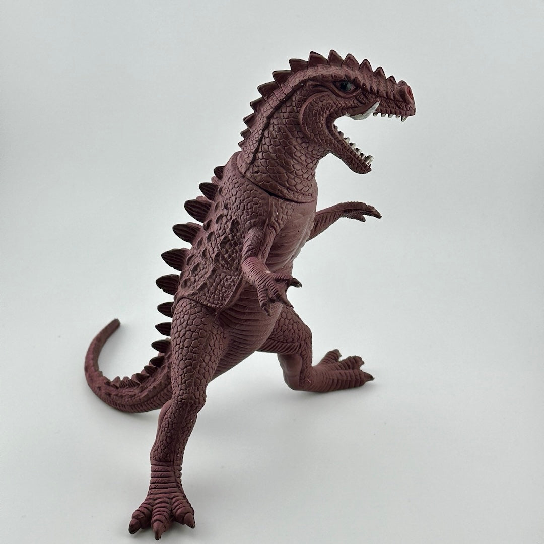 Side view of purple dinosaur type animal with white tusks & teeth, black eyes, long tail.
