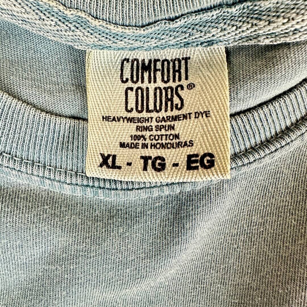 Close-up of crewneck t-shirt's neck tag with 'Comfort Colors' brand and size XL.