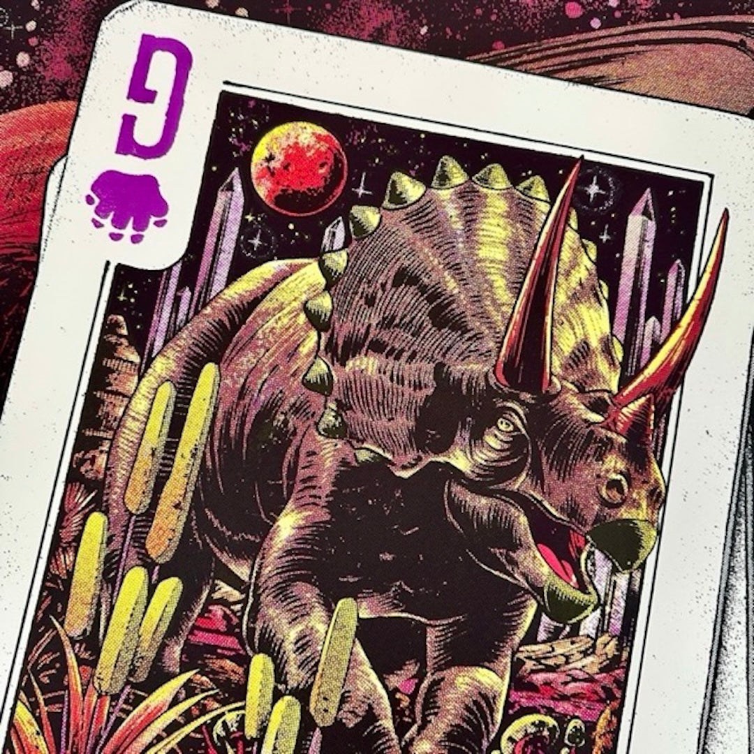White playing card with dinosaur artwork and red planet.