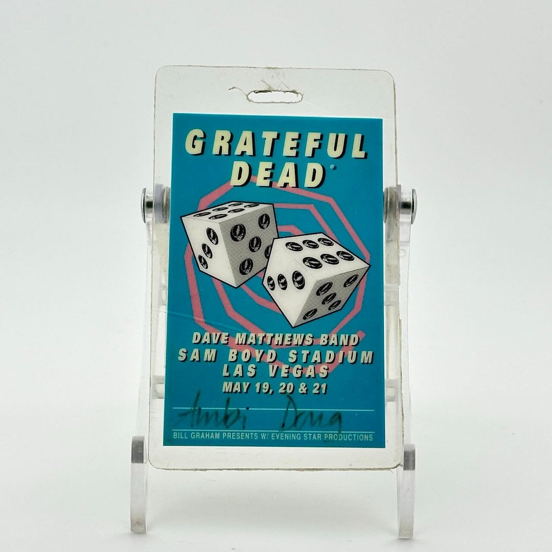 Laminated cyan blue backstage pass with pink swirl in back of two dice, white block text for event info.