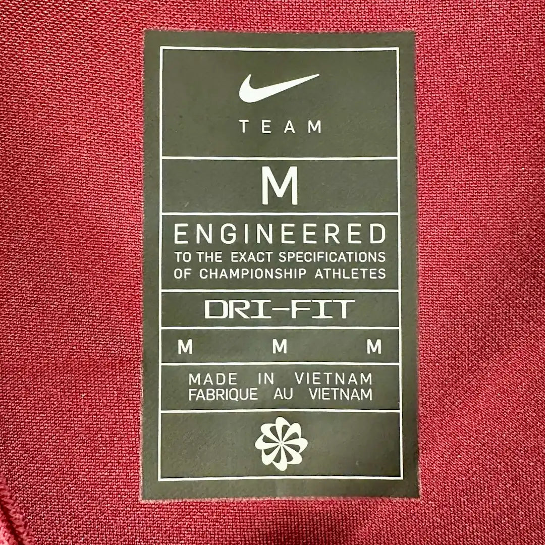 Close up of back neck tag showing manufacturing, fabric, & size information.