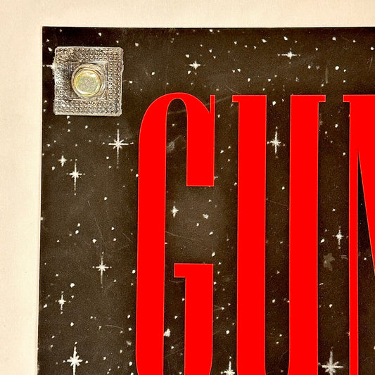 Red text 'GUN' on a black background with star-like shapes