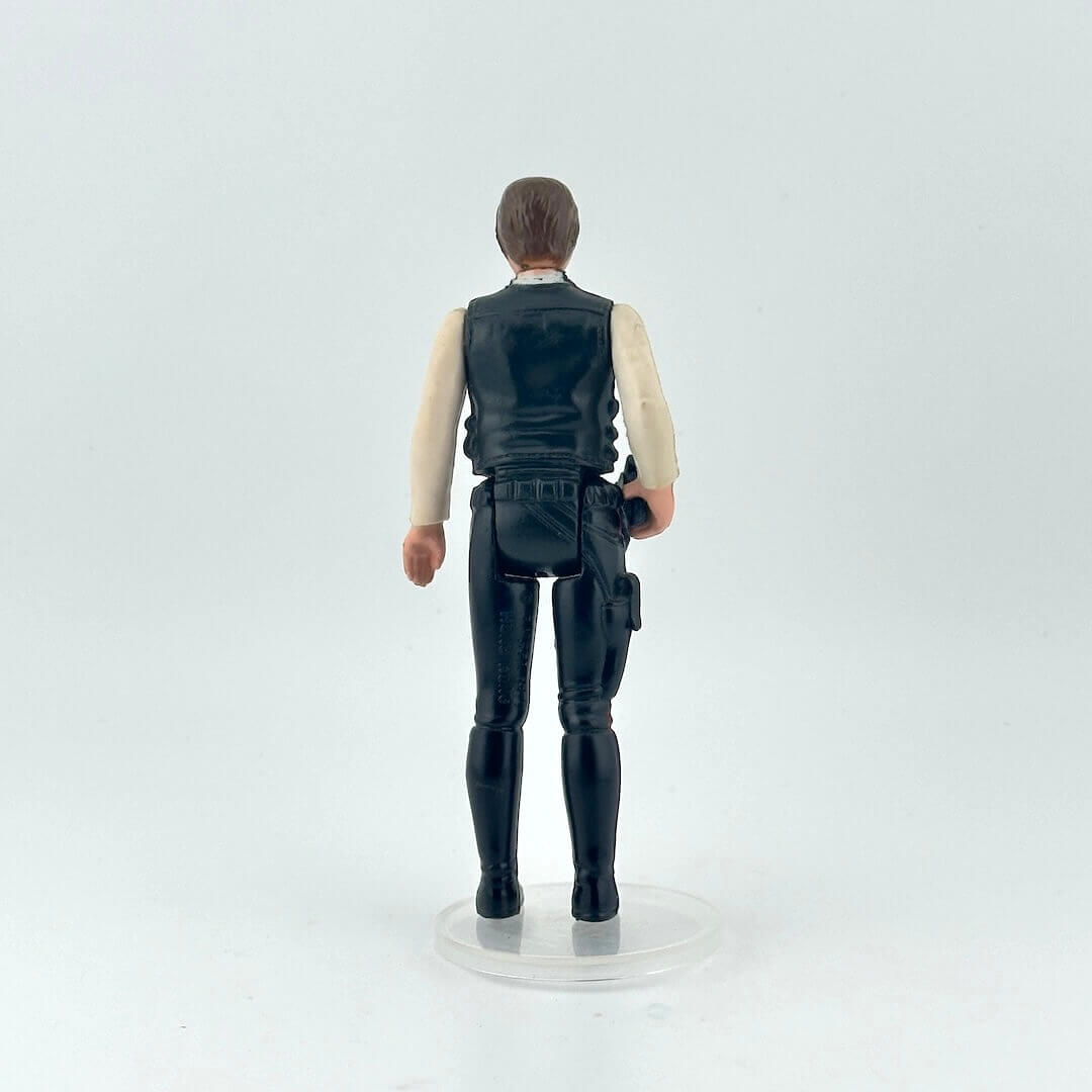 White male action figure in a white shirt, navy vest and pants on a white background