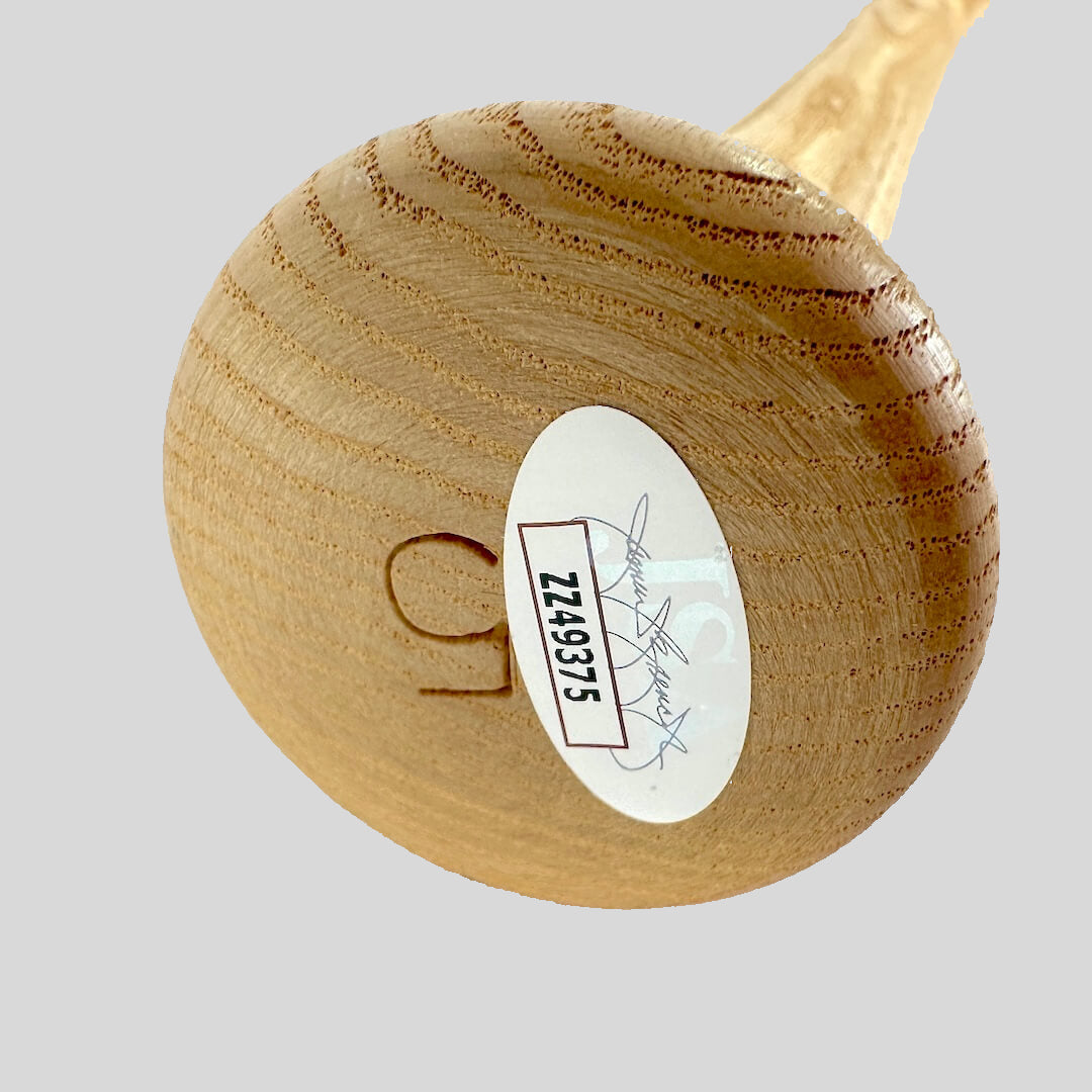 Wooden baseball bat with a JSA authentication sticker on a light background