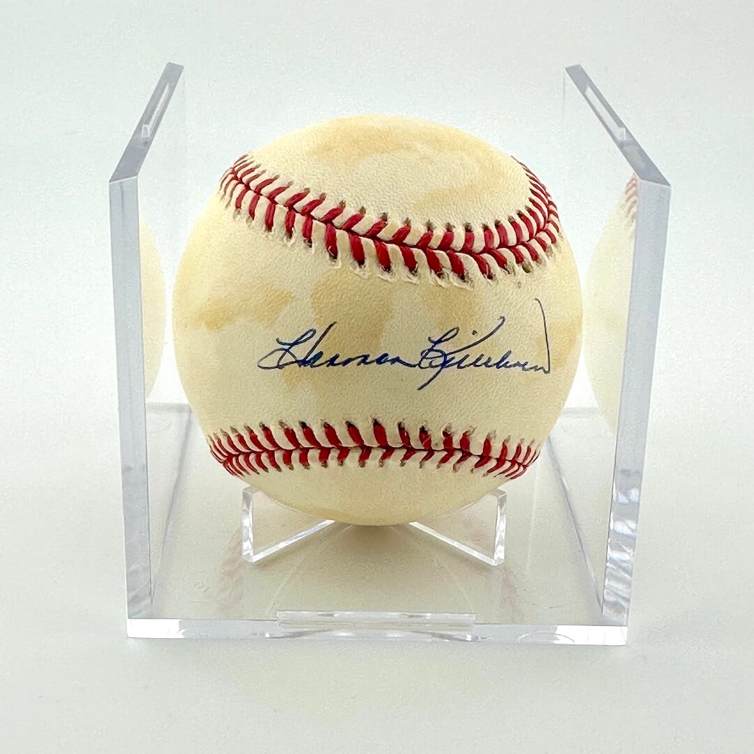 Signed baseball in clear display against white background.