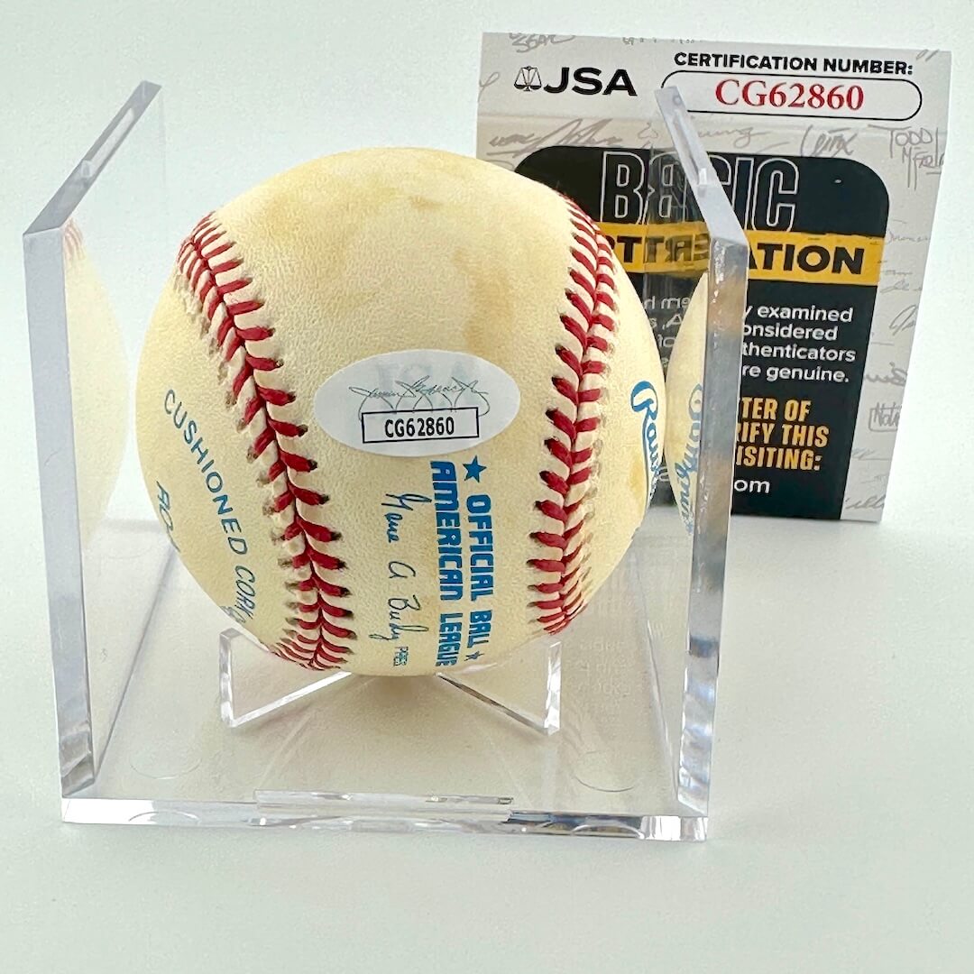 Signed baseball in clear display against white background with JSA certificate.