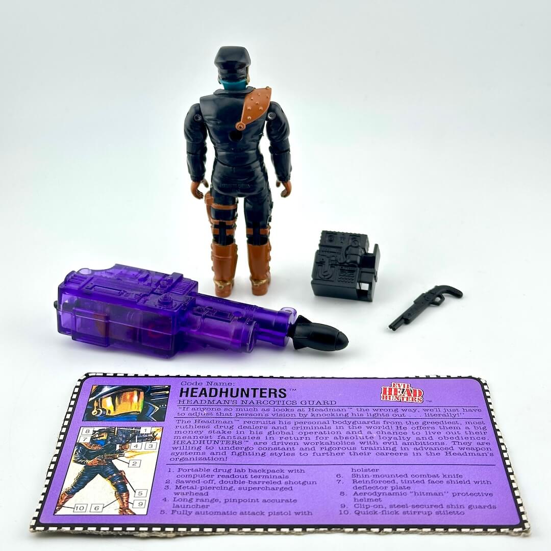 GI Joe action figure with three accessories and character card, photographed against white background.