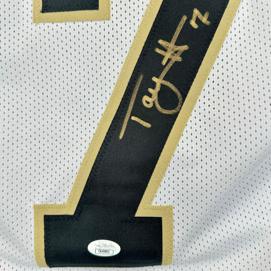 Black number 4 with gold border on a white background, featuring a signature.
