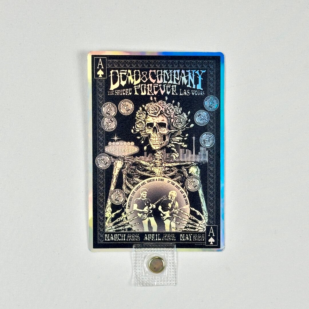 Promotional sticker for 'Dead & Company Forever' concert featuring a skeleton and musicians, on a rainbow foil background.
