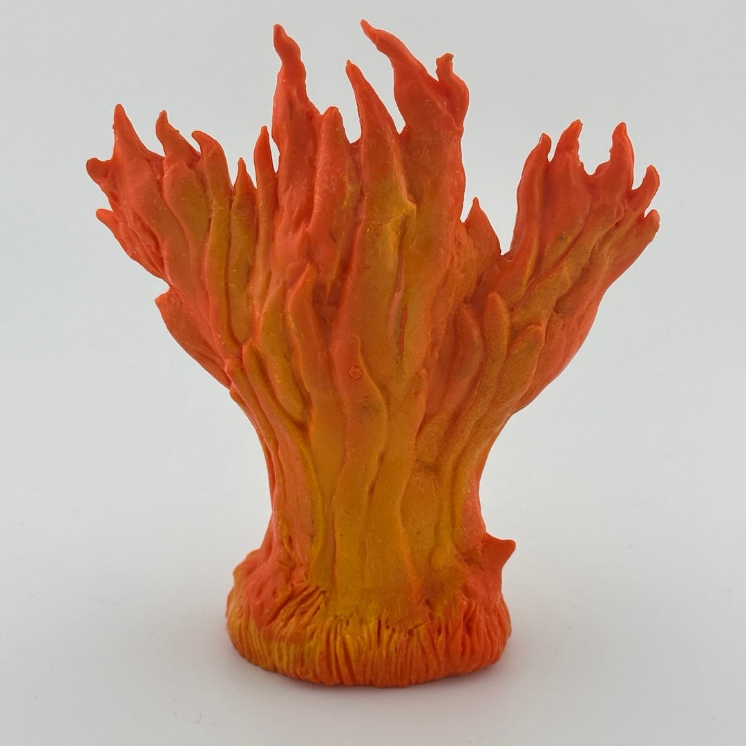 Image of backside of action figure of column of flames rising into shape of head & raised arms.