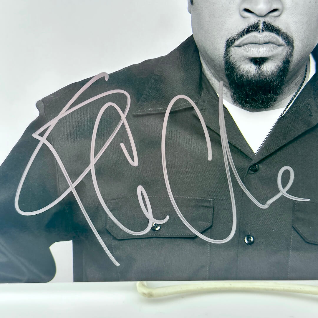 Close up of silver marker signature on shoulder and chest of photo of Ice Cube.