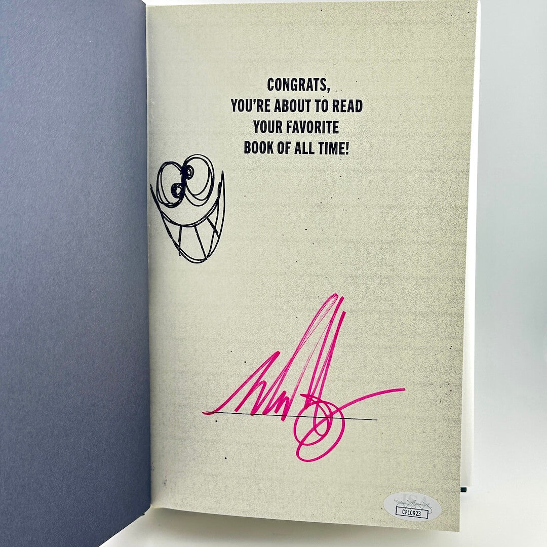 Book with a humorous message and signature on a plain background