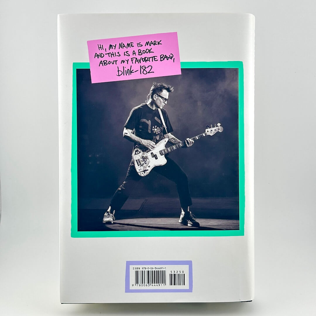 Book cover with a photo of a person playing bass guitar and a pink sticky note.