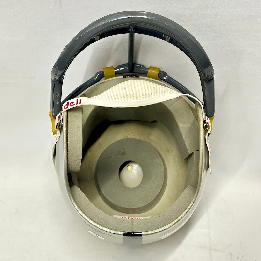 Inside of silver football helmet with gray faceguard and padding inside.