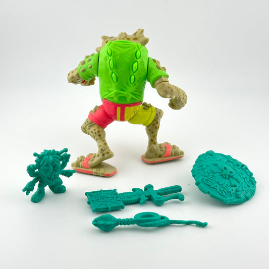 Backside of action figure of anthropomorphized toad character with teal accessories.