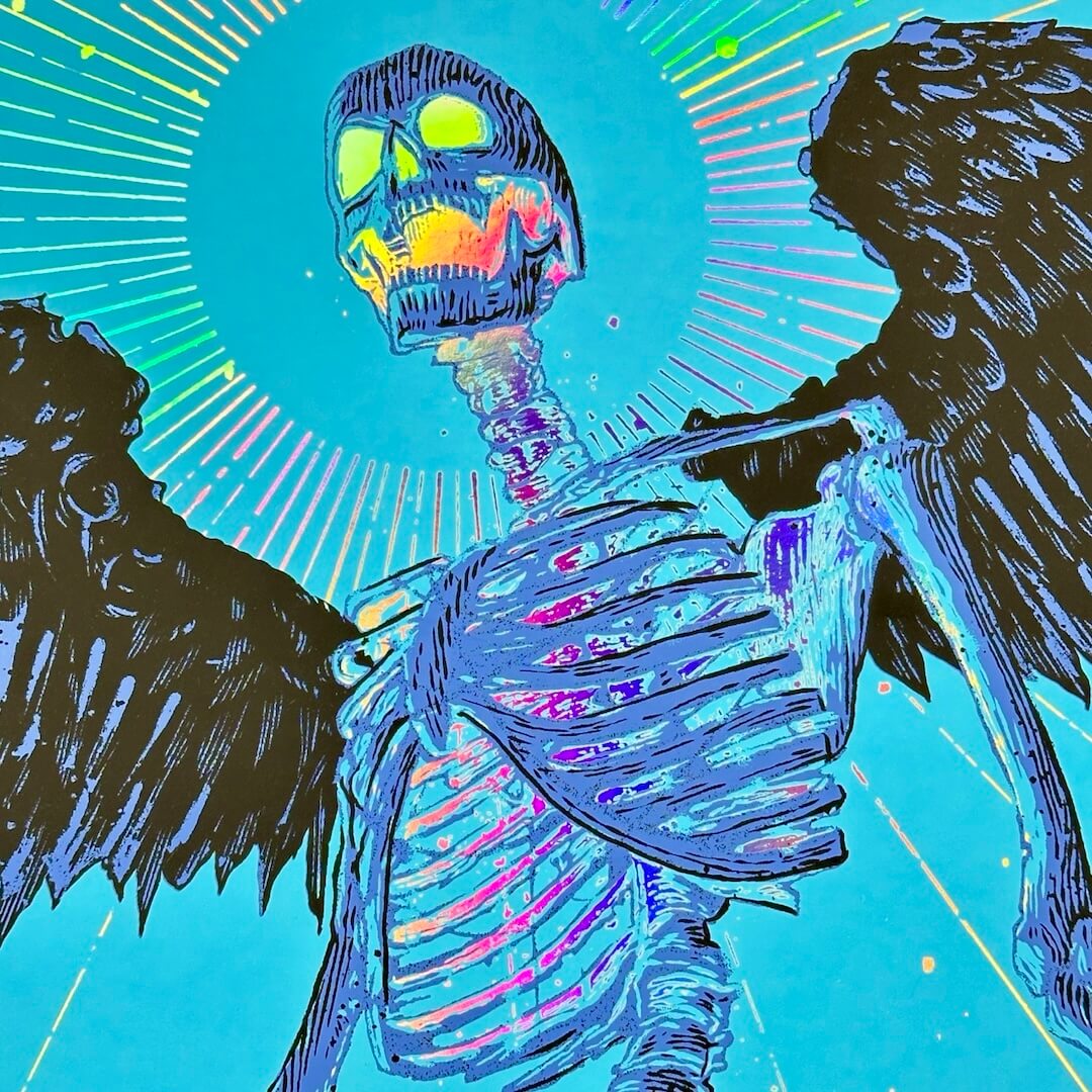 Close up of main winged skeleton with rainbow foil details in chest, neck & skull.