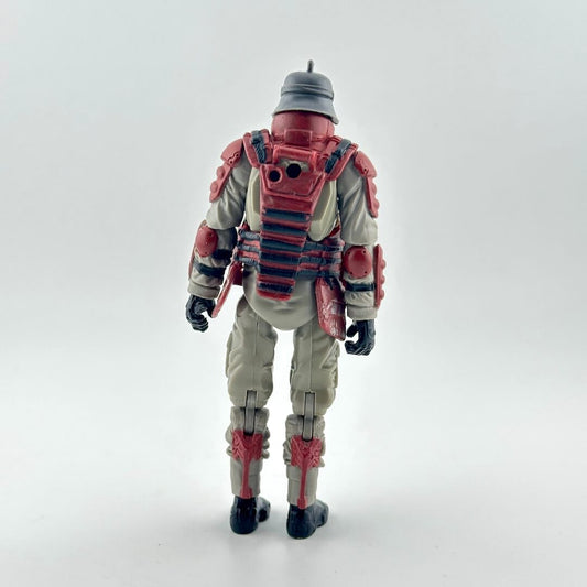 Action figure of a soldier shown from the back, wearing a beige jumpsuit with red armor plating, a gray helmet, and black boots.