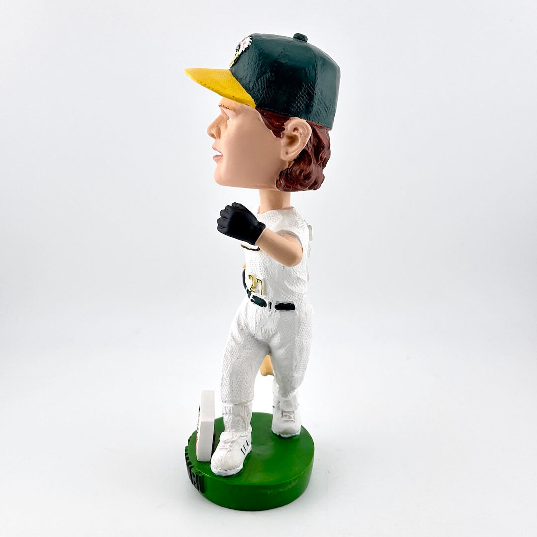 Bobblehead of a baseball player in a white uniform with green accents on a white background