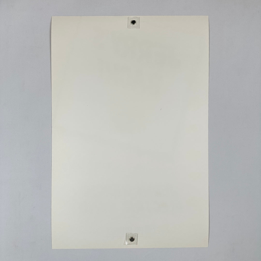 White sheet of paper with two magnets on a gray background