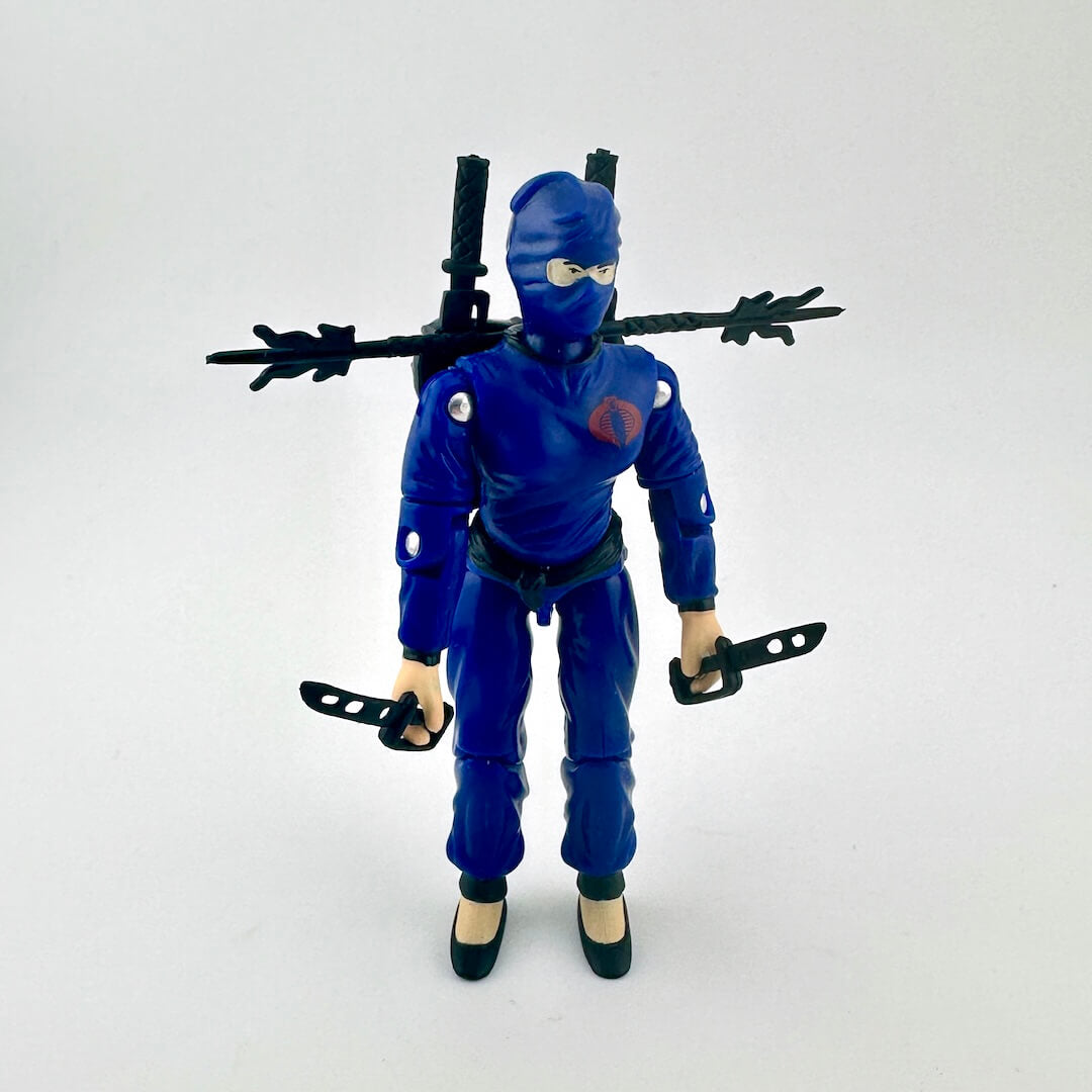 Blue action figure with a mask and weapons on a white background