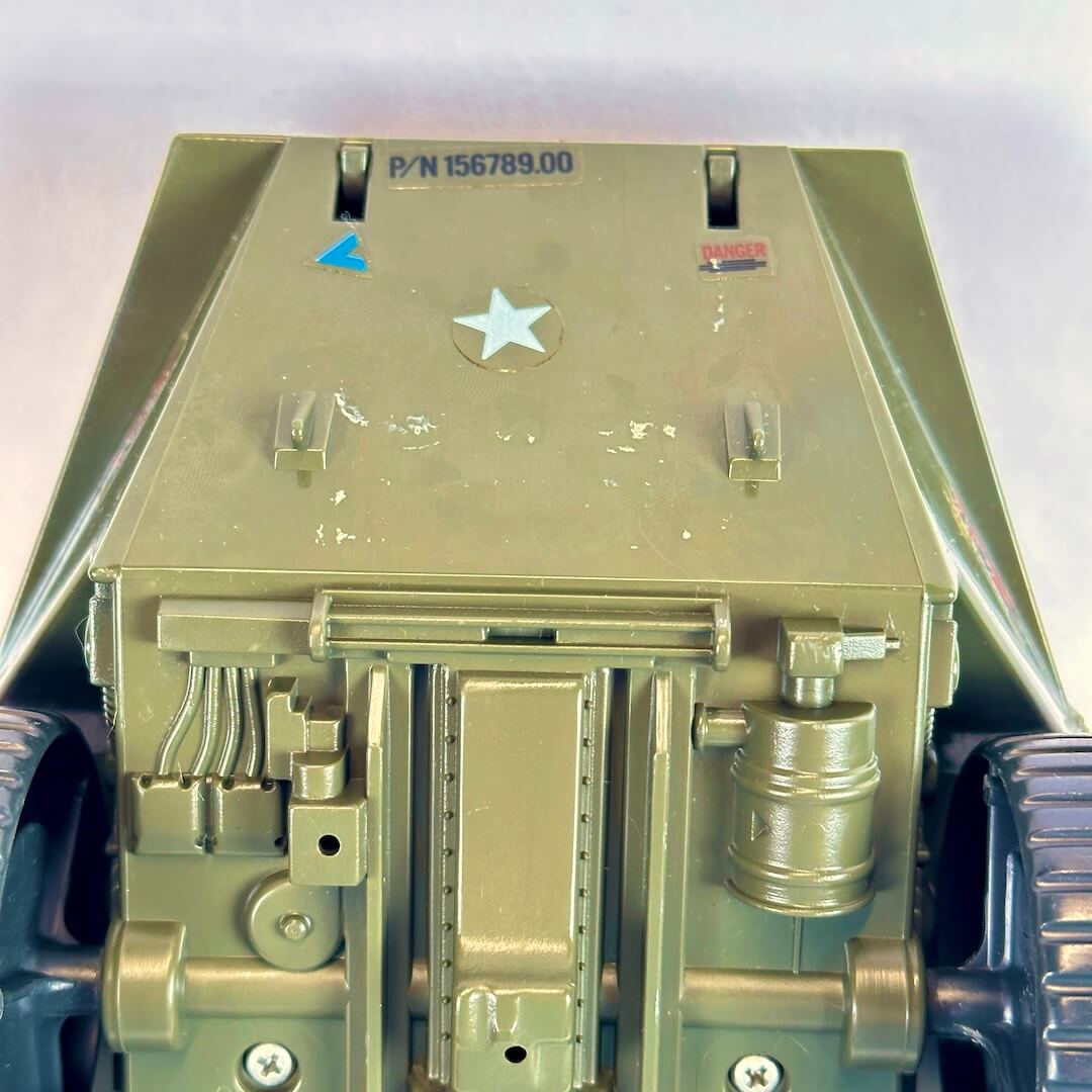 Close-up of the top deck of a vintage military model vehicle, showing painted olive drab details.