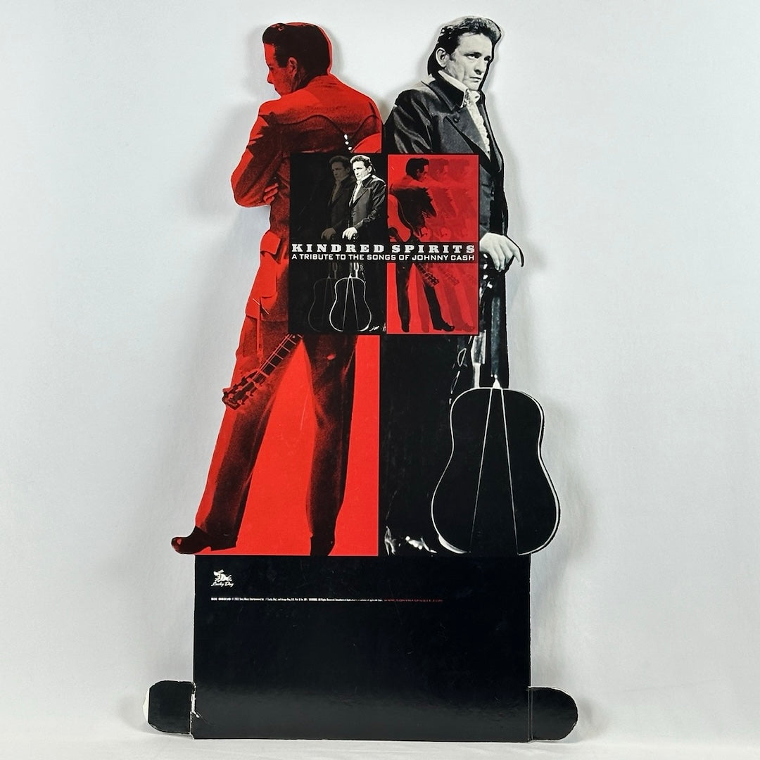 Two images of Johnny Cash back to back, one red, one black. Both behind image of album cover, above black base.