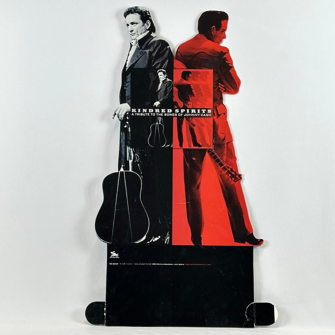 Two images of Johnny Cash back to back, one red, one black. Both behind image of album cover, above black base.