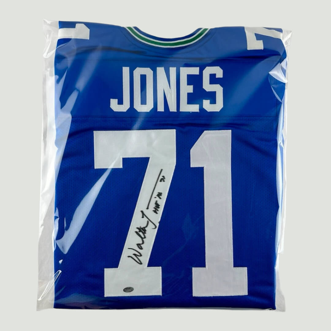 Blue football jersey with white sewn on numbers and nameplate. Jones #71 signed in black marker.