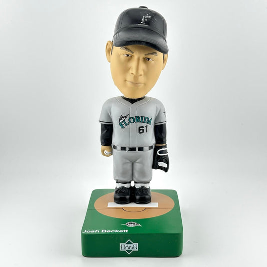 Bobblehead figure of a baseball player in a gray uniform with a cap on a white background