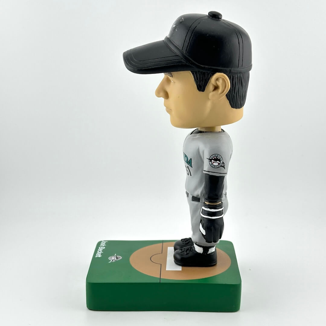 Bobblehead figure of a baseball player on a green base with a white background