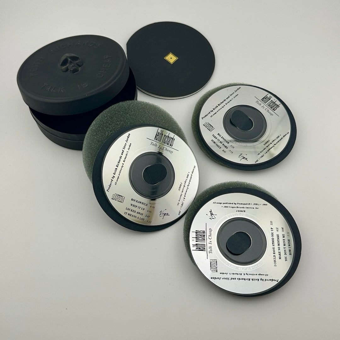 Black circular tin with 3 mini CDs & foam padding for between.