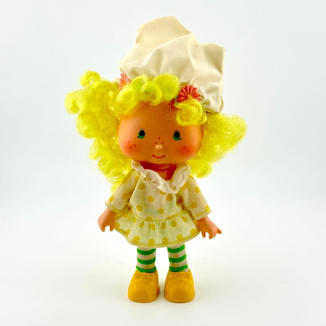 Toy figure with yellow hair and outfit on a white background